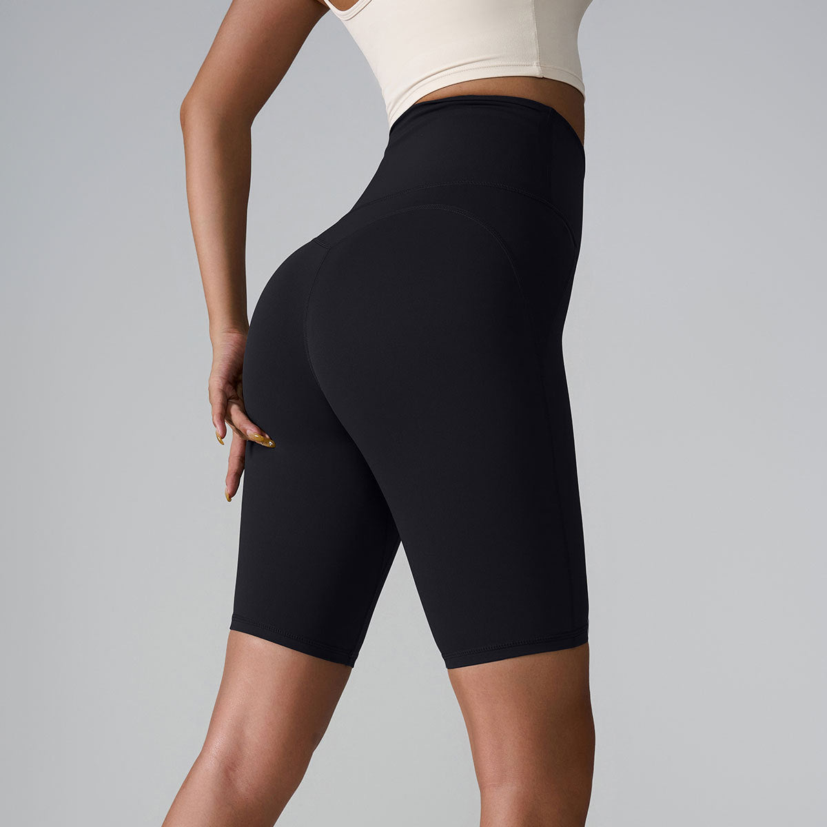 Black high-waisted compression shorts with seamless design and sculpting silhouette, shown with white crop top