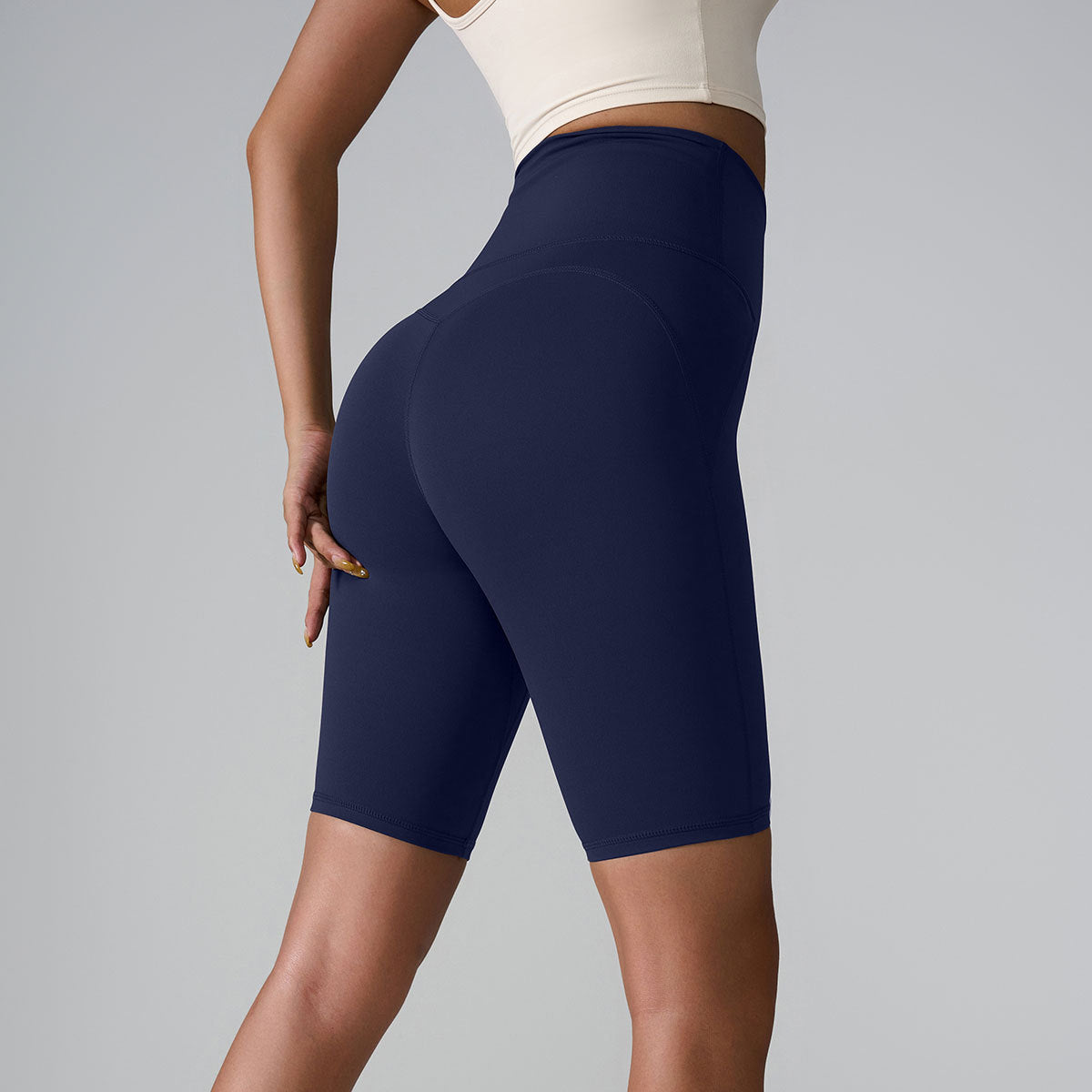 Navy high-waisted compression shorts with seamless design and sculpting silhouette, shown with white crop top