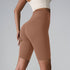 Mocha brown high-waisted biker shorts with compressive fabric and seamless design against gray backdrop