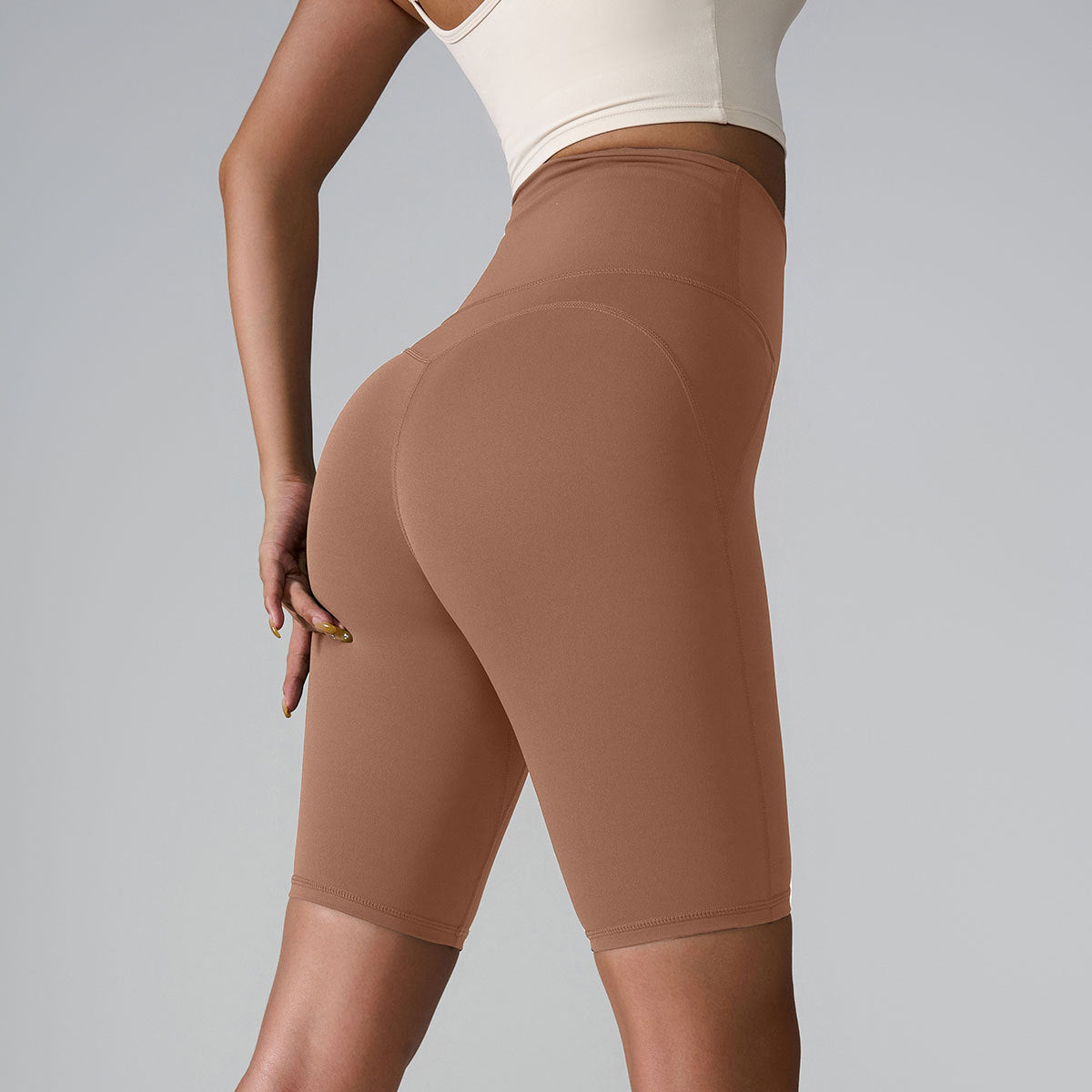 Mocha brown high-waisted biker shorts with compressive fabric and seamless design against gray backdrop