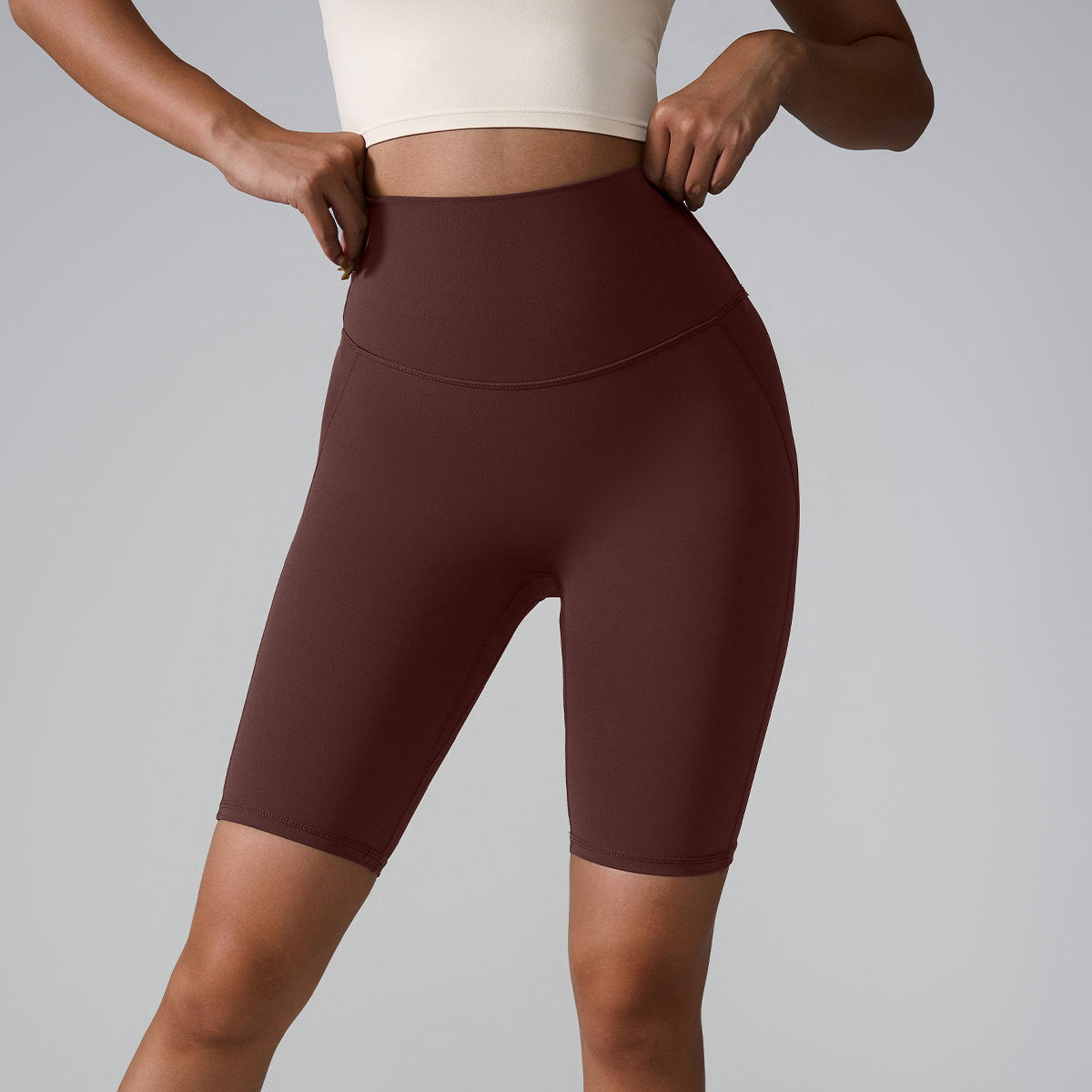 Burgundy compression bike shorts with high waistband and sculpting seams, paired with white crop top