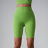 Lime green high-waisted athletic shorts with matching sports bra, showing compression fit