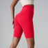 Red high-waisted athletic shorts with sculpting seams and compression fit against light background