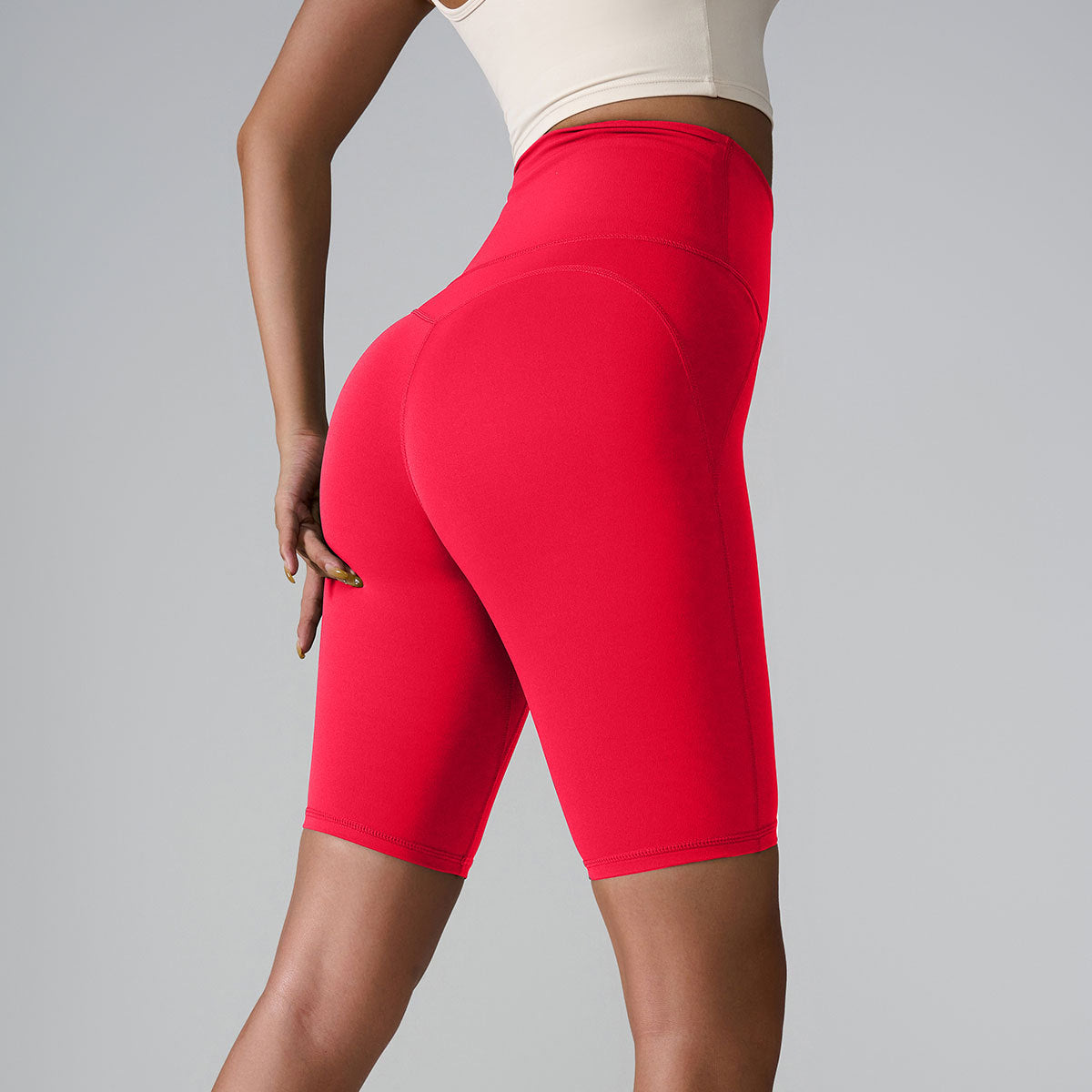 Red high-waisted athletic shorts with sculpting seams and compression fit against light background