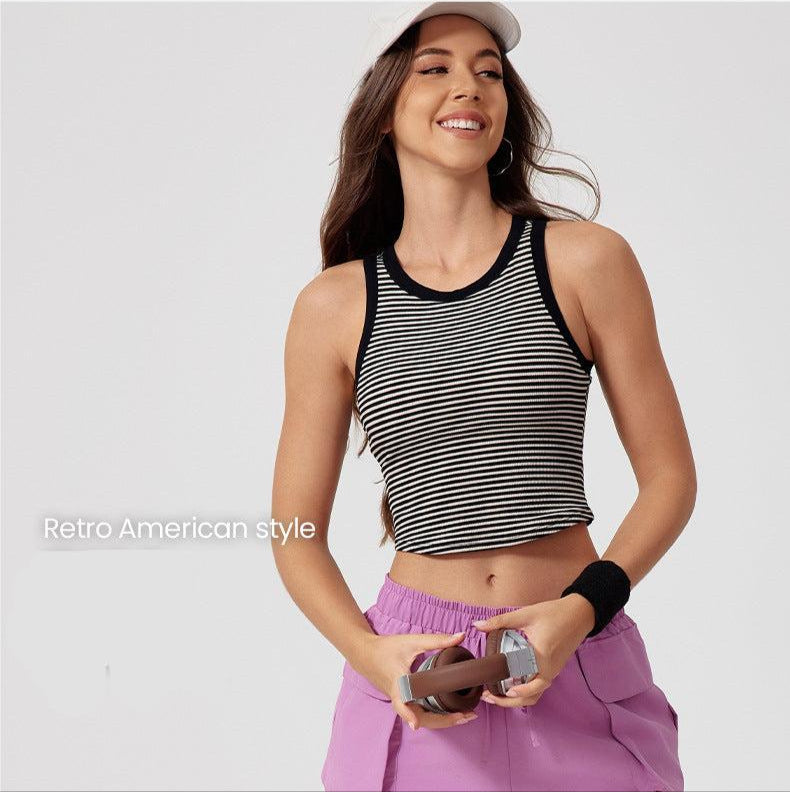 A smiling woman in white Nike cap wearing striped crop tank with white trim paired with lilac cargo pants, shown against clean background