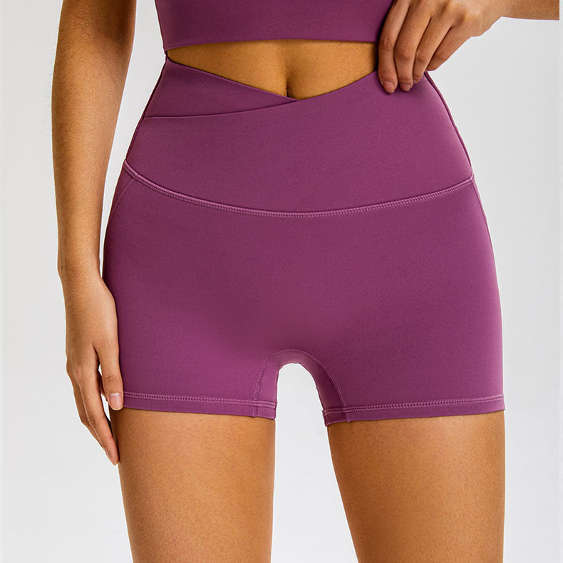 Purple athletic shorts with high-rise crossover waistband and seamless compression fit