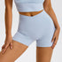 Powder blue compression shorts featuring crossover waistband design and matching sports bra