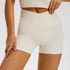 Cream colored athletic shorts with high-rise crossover waist and second-skin compression fabric