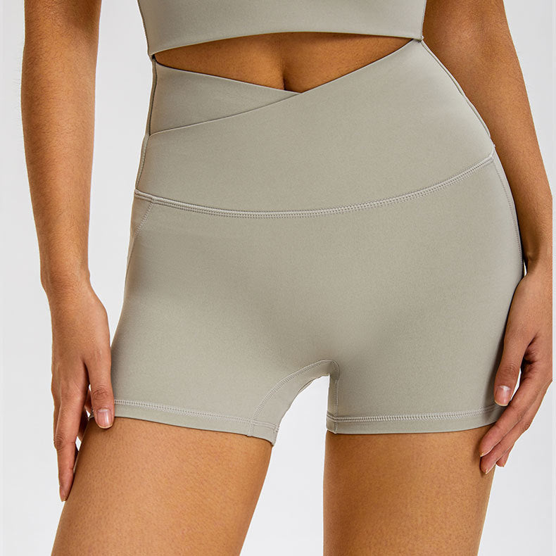 Light gray athletic shorts featuring crossover high waist and four-way stretch material