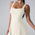 A model wearing ivory white square neck dress with wide straps and flared silhouette, photographed against light background
