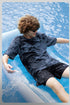 Male model in black moisture-wicking tee relaxing poolside