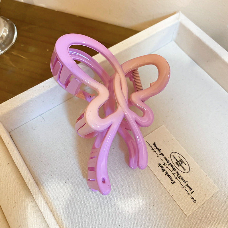 A light purple gradient butterfly-shaped hair claw with a smooth color transition, displayed in a jewelry box.