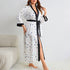 White robe with small multicolored hearts, black trim, worn in living room setting
