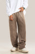 Person wearing taupe wide-leg sweatpants with white sweater, silver watch and white sneakers, showing relaxed streetwear styling