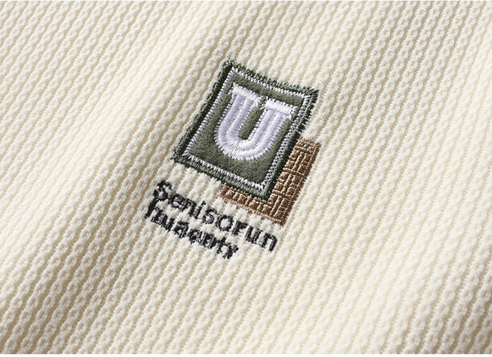 Embroidered U logo patch detail in olive and white