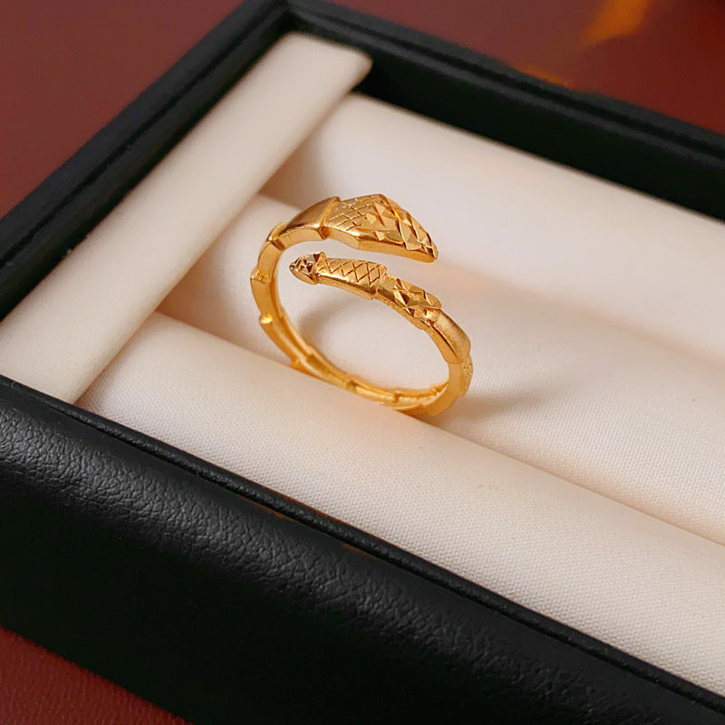 Gold snake ring with textured pattern in jewelry box