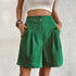 Model wearing Green pleated shorts with dual button closure and side pockets, paired with white crop top