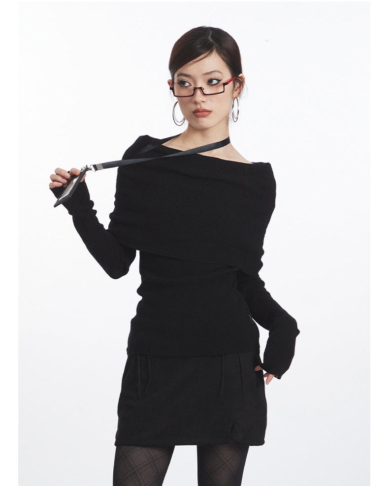 Black off-shoulder knit top with dramatic folded neckline, fitted waist, and long sleeves. Front detail with lanyard.