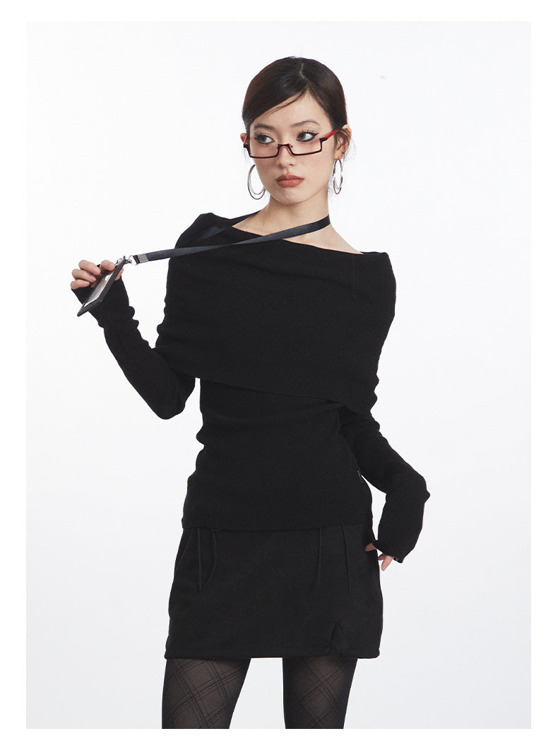 Black off-shoulder knit top with dramatic folded neckline, fitted waist, and long sleeves. Front detail with lanyard.