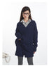 Navy cable knit set: Oversized V-neck sweater styled over striped shirt, paired with matching knit shorts in same cable pattern. Preppy academic styling.