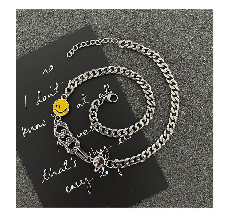 Necklace  displayed on black handwritten text background, showing coordinated Cuban chain design with smiley charm and snake accents