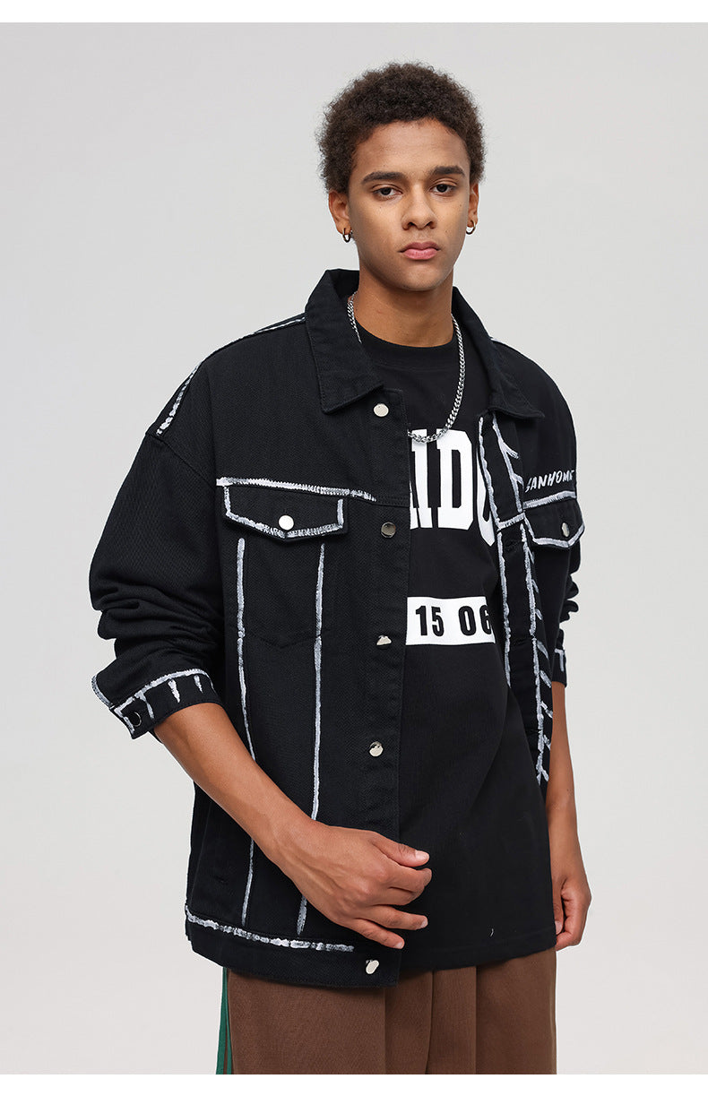 A man is posing against a gray background wearing a black SANHOMME outline jacket with rolled sleeves and brown pants.