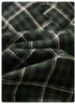 Close-up of green plaid tartan fabric texture with white grid pattern against dark background
