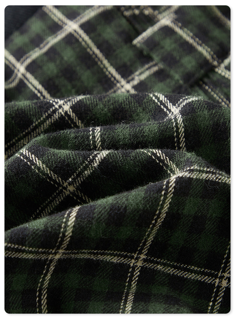 Close-up of green plaid tartan fabric texture with white grid pattern against dark background