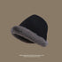 Black bucket hat with gray faux fur trim, angled view showing texture contrast, structured crown, winter beach accessory