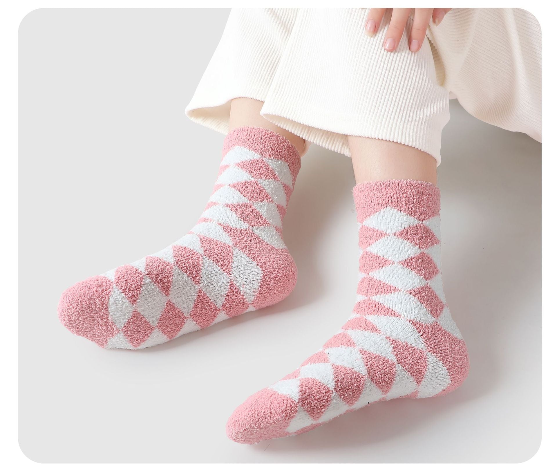 Pink and white argyle patterned fuzzy socks worn with white sweater