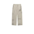 Cream Backstairs wide-leg sweatpants with elastic waistband, drawstring ties, side pockets, distressed paint effect pattern and gray logo print