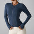 A model is wearing a navy blue fitted sports jacket with front zip and sculpting seams paired with cream leggings. Functional athletic design
