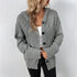 Gray oversized button-up cardigan with ribbed sleeves, paired with a white crop top and black jeans, featuring a delicate gold necklace