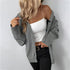 Gray knit cardigan styled with a white one-shoulder top, black high-waisted jeans, and a gold buckle belt, showcasing a casual chic look