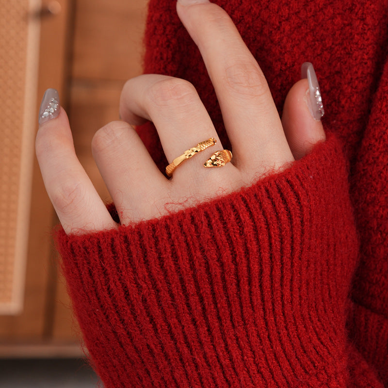 Close-up of adjustable gold snake ring on hand with red sweater