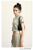 Olive green mock neck crop top with front zip and white sleeve stripes, side view
