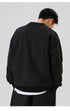 Back view of the black oversized sweatshirt, emphasizing its clean and simple design