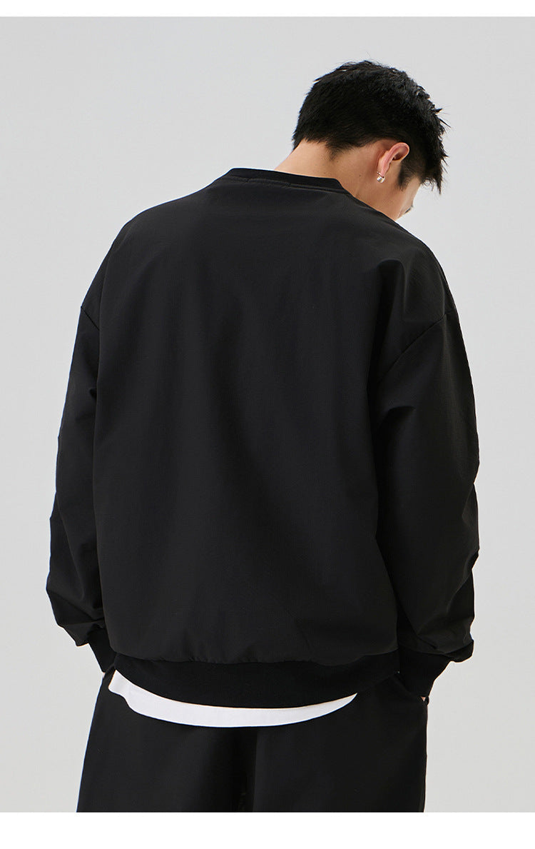 Back view of the black oversized sweatshirt, emphasizing its clean and simple design