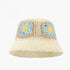 Cream crochet bucket hat with blue and yellow granny square floral patterns, labeled UPF50+ for sun protection.
