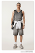 Male model wearing a gray ombre tank top and matching shorts with a white sweater tied at the waist, accessorized with silver jewelry and sneakers