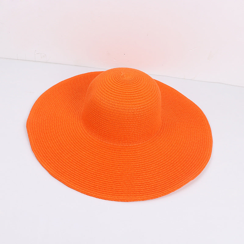 Orange wide-brimmed sun hat with a structured design, laid flat against a white background.