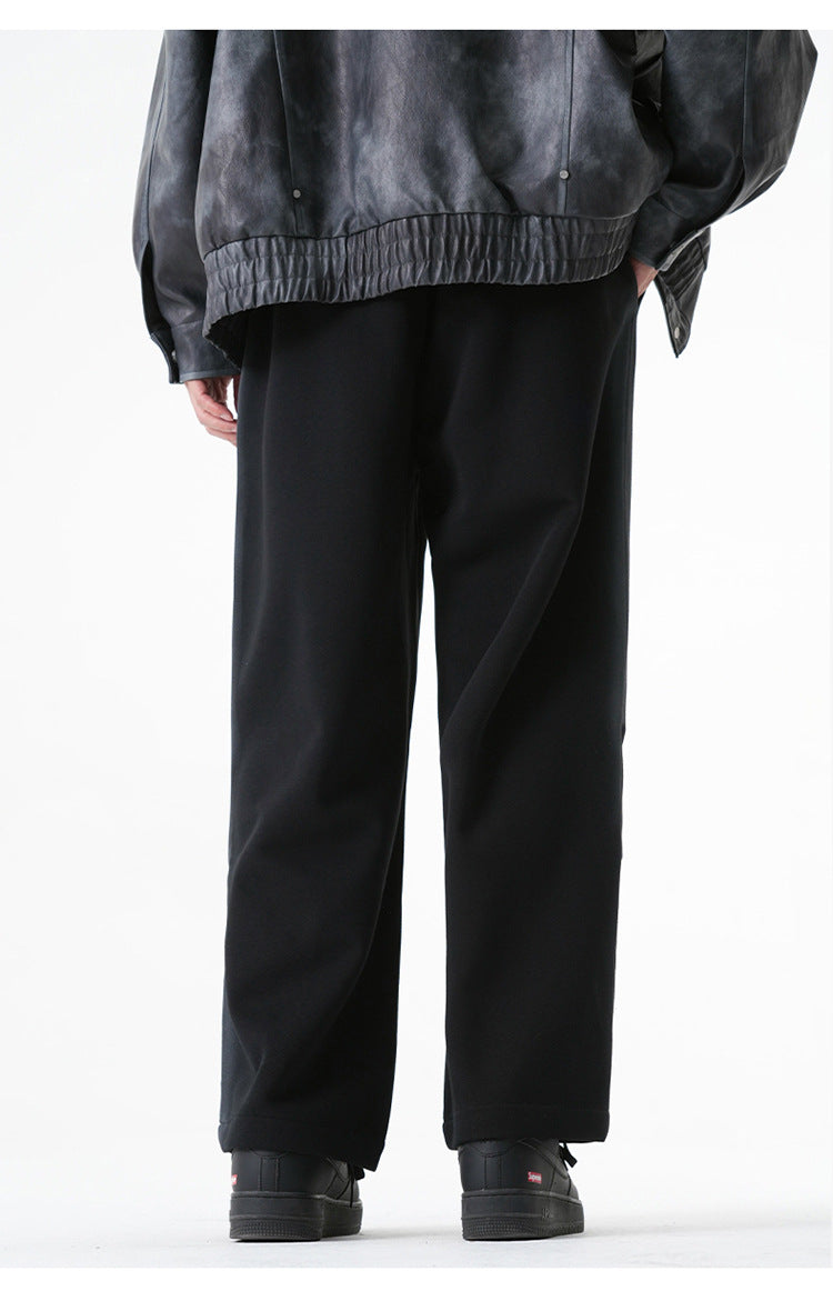 Back view of black wide-leg pants highlighting their loose fit and drape