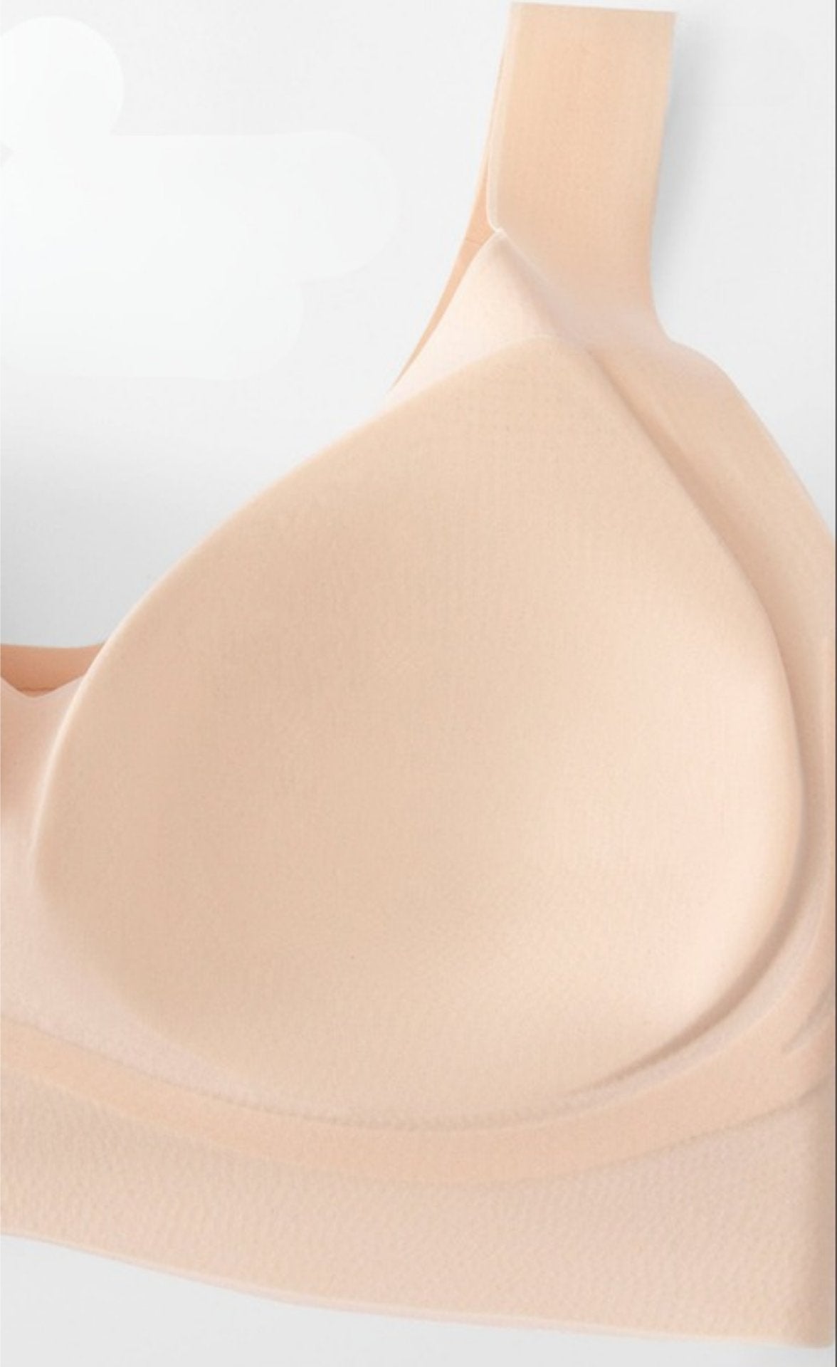 Close-up of a beige seamless bra highlighting the fixed cup padding.
