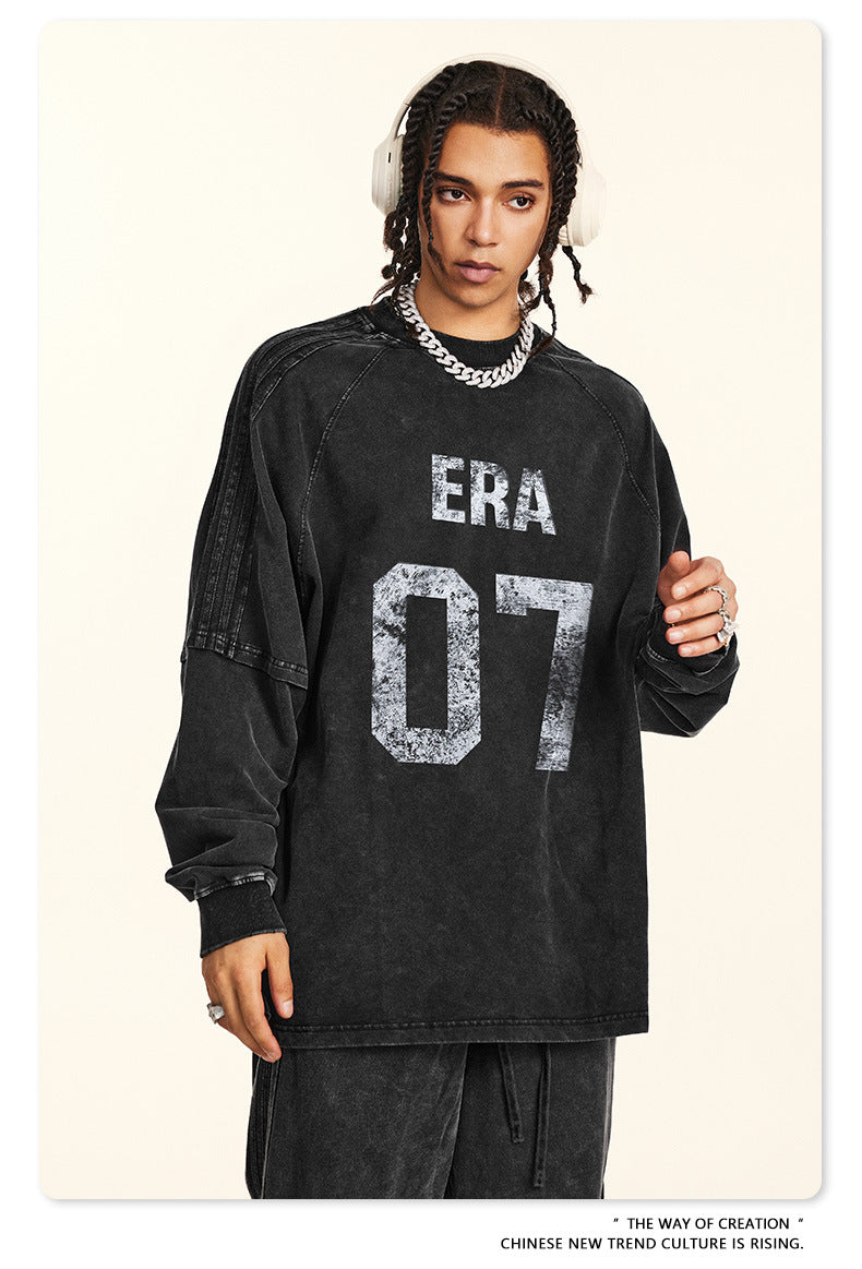 Close-up of black 'ERA 07' sweatshirt front with silver chain accessory
