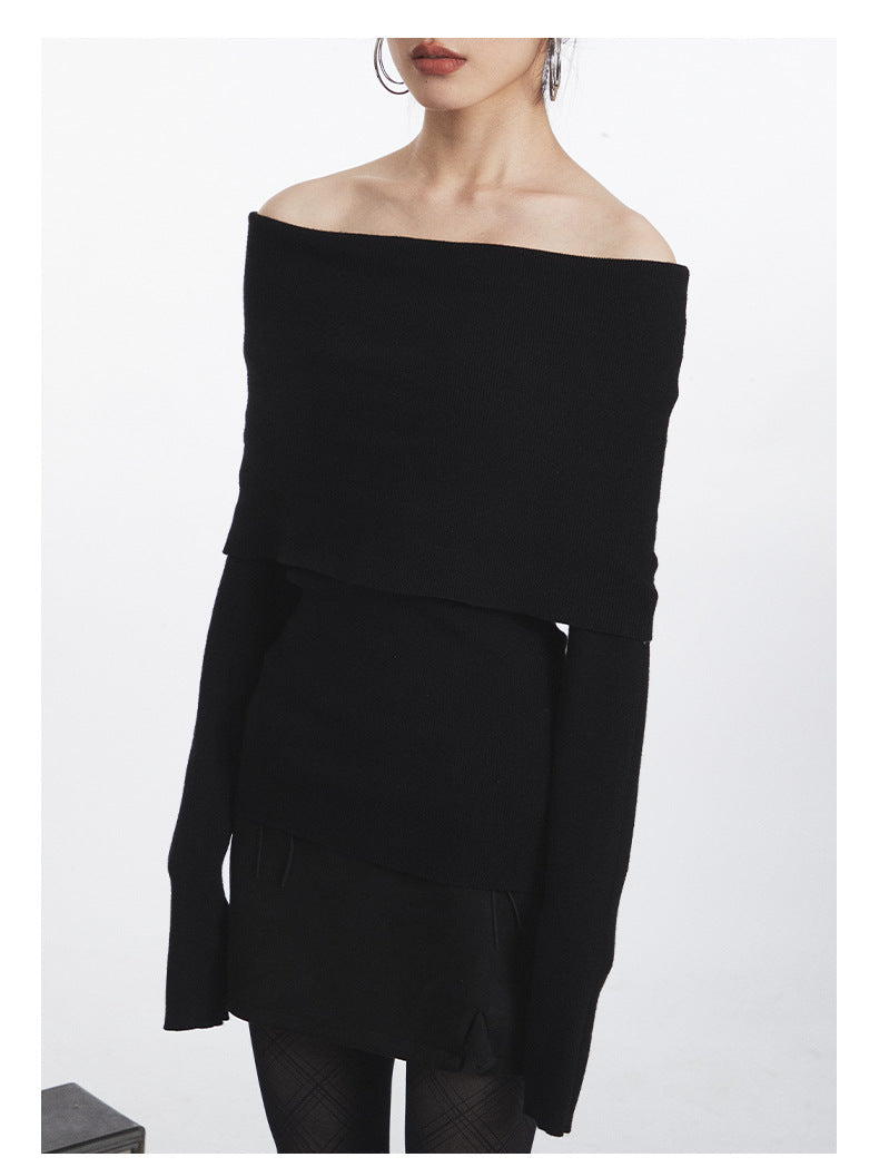 Black ribbed off-shoulder sweater with layered fold-over design and fitted long sleeves. Close-up detail of neckline construction.