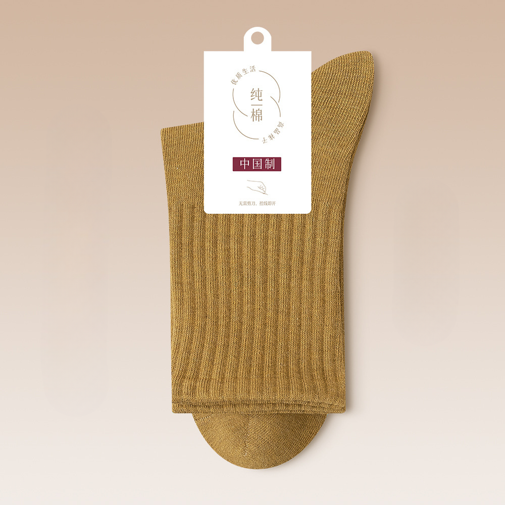 Mustard yellow ribbed sock displaying pure cotton certification tag