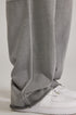 Detail shot of grey sweatpants hem and seam construction, showing relaxed fit over white Air Force 1 sneakers