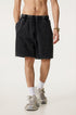 Image 1: "A man wearing black vintage wash athletic shorts with elastic waistband standing with white socks and chunky sneakers against neutral background