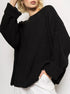 Close-up of black chunky knit sweater with ribbed texture against white background