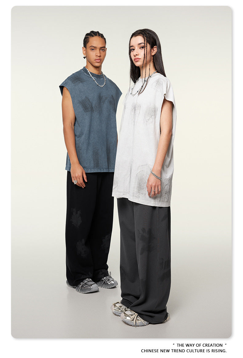 Two models in gray and white t-shirts with dark pants standing side by side against cream background